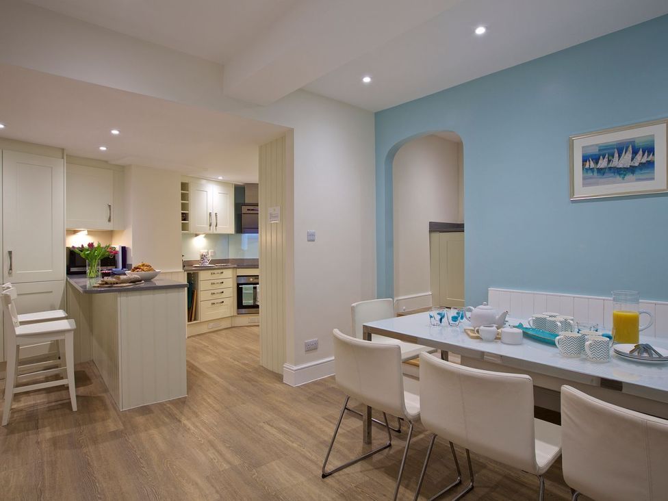 A kitchen with dining area and tea set at 4 The Salcombe in Salcombe