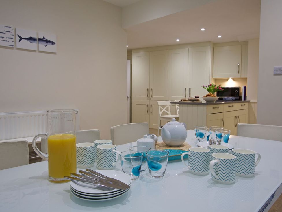 A kitchen with a dining table set up for breakfast at 4 The Salcombe in Salcombe