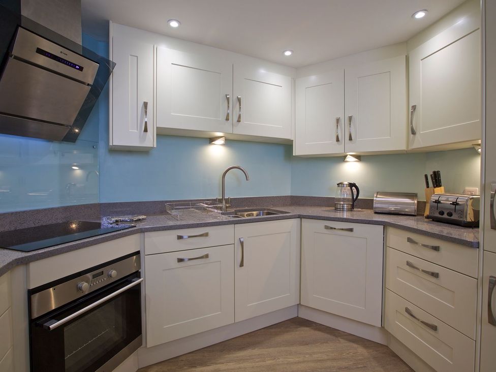 A kitchen with cabinets, sink, stove, oven, kettle, and toaster at 4 The Salcombe, Salcombe
