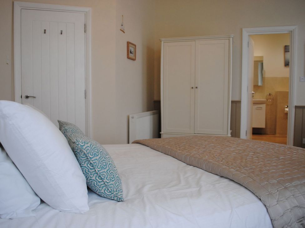 A bedroom with a bed and wardrobe at 4 The Salcombe in Salcombe