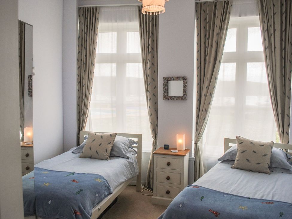A bedroom with two beds and a nightstand at 4 The Salcombe in Salcombe