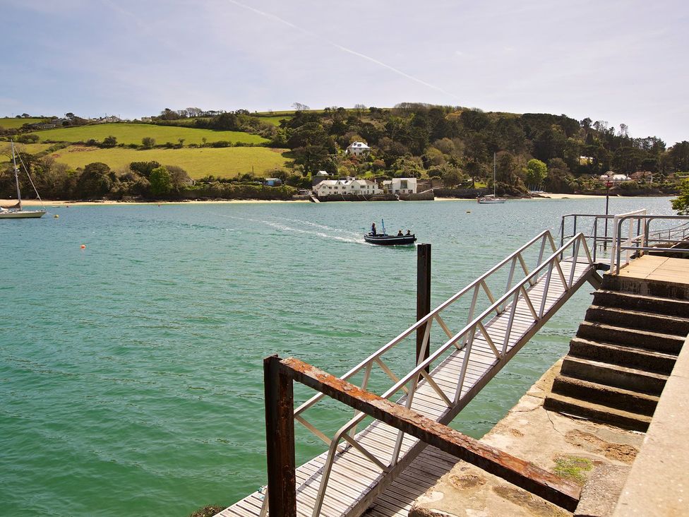 A jetty with steps and a boat on water at 4 The Salcombe, Salcombe