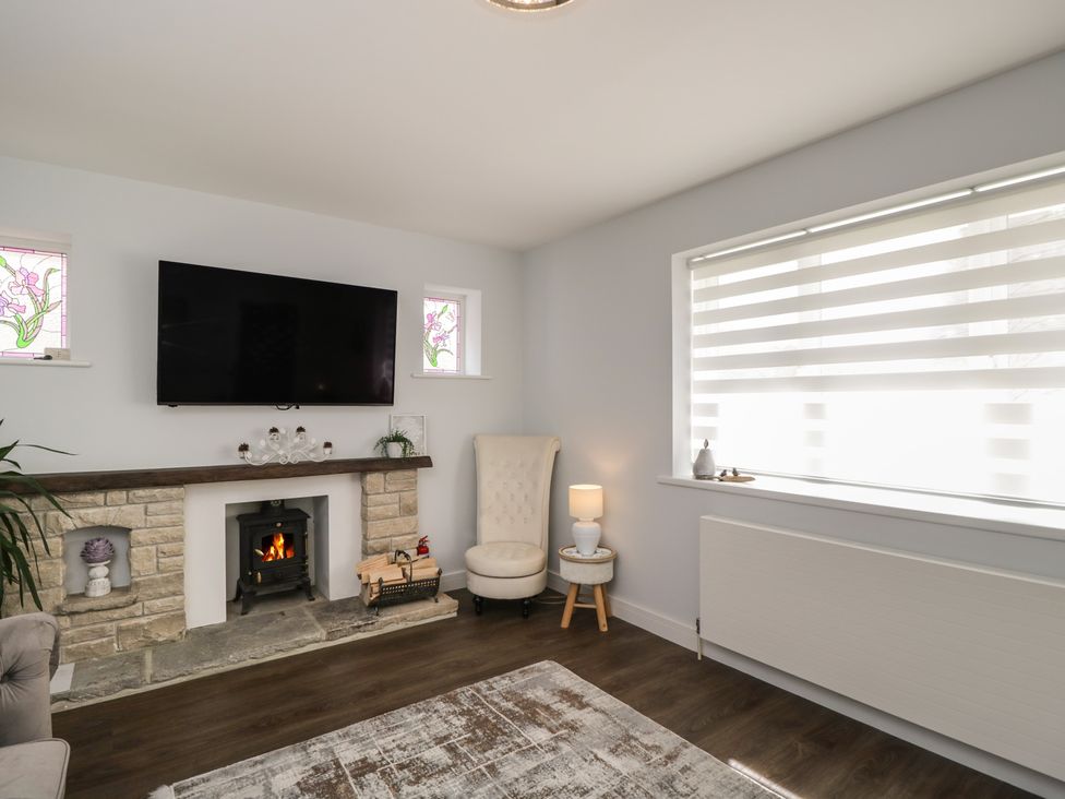 A living room with a fireplace and television at The Laurels in Wimborne Minster