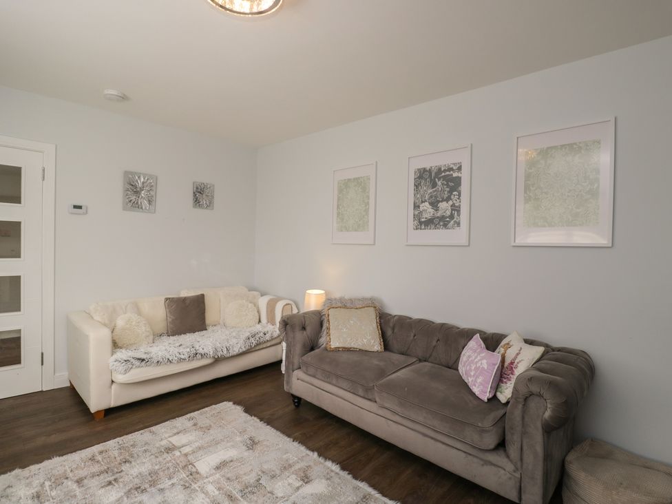 A living room with two sofas and framed pictures on the wall at The Laurels in Wimborne Minster
