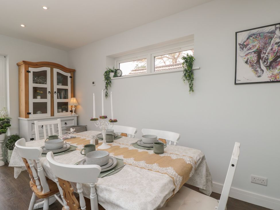 A dining room with a table set and a cabinet at The Laurels in Wimborne Minster