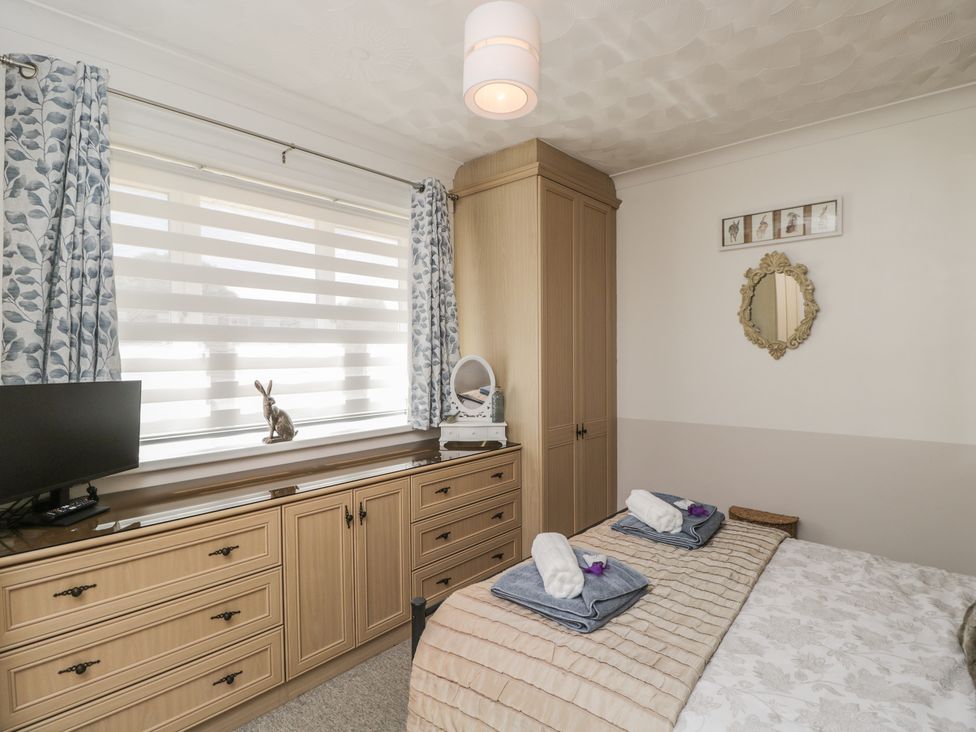 A bedroom with a bed and television at The Laurels Wimborne Minster