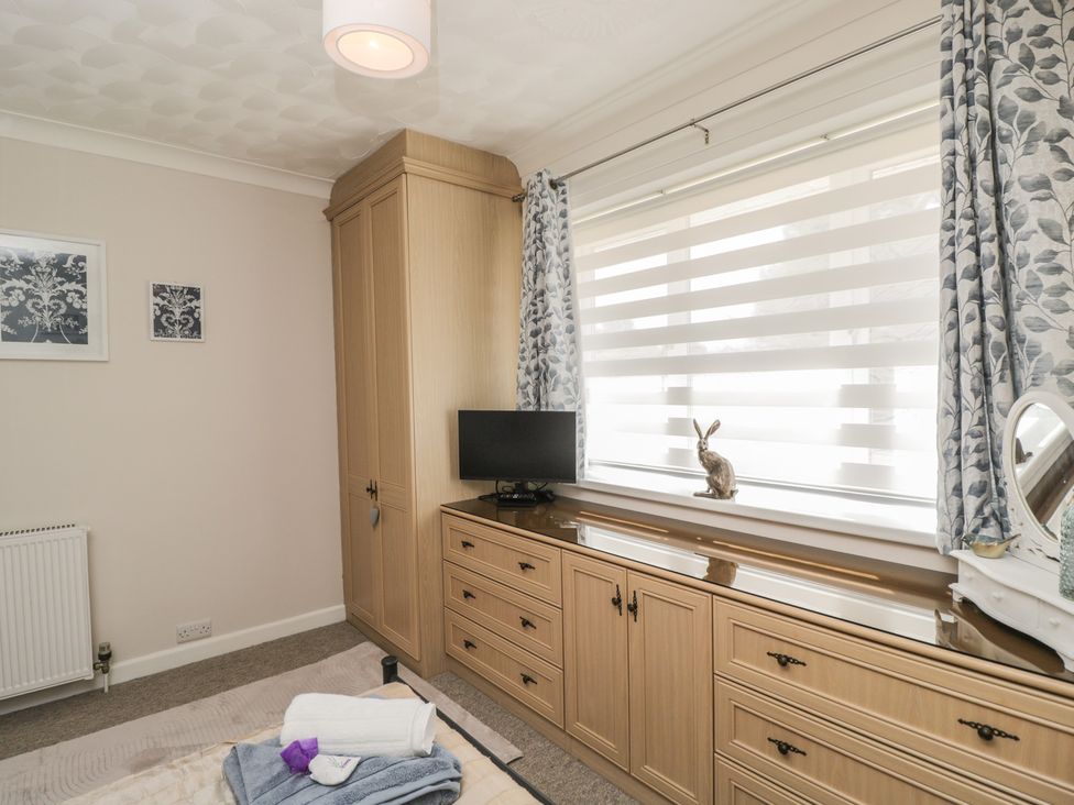 A bedroom with a wardrobe and television at The Laurels in Wimborne Minster