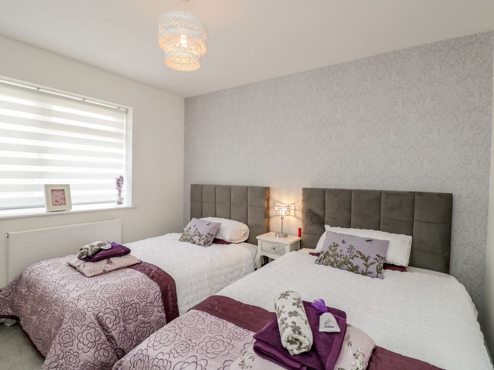 A bedroom with two single beds and a bedside table at The Laurels in Wimborne Minster