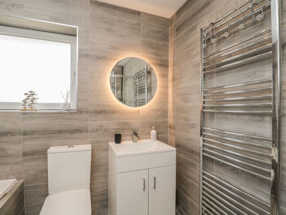 A bathroom with a sink, toilet, and mirror at The Laurels in Wimborne Minster