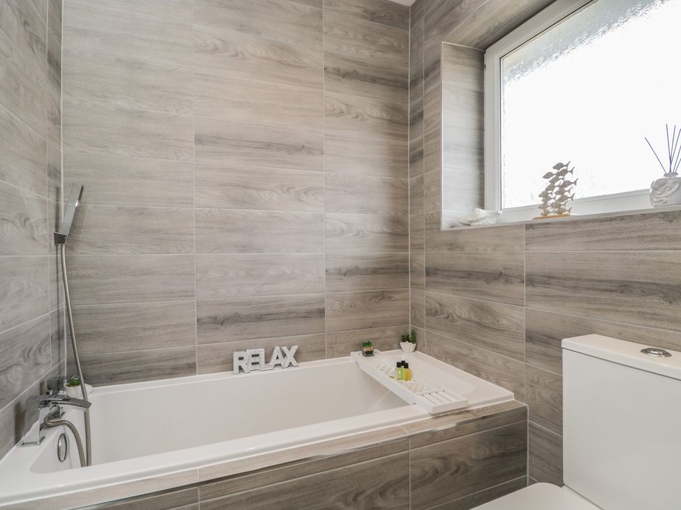 A bathroom with a bathtub and toilet at The Laurels in Wimborne Minster