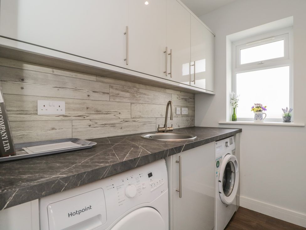A laundry room with a washing machine and sink at The Laurels in Wimborne Minster