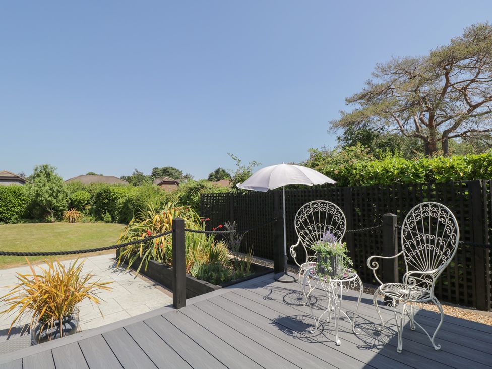A garden with two chairs and an umbrella at The Laurels in Wimborne Minster