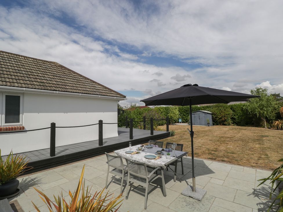An outdoor dining area with a table and umbrella at The Laurels in Wimborne Minster
