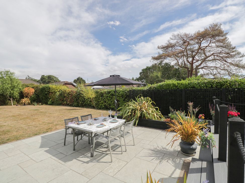 A garden with a dining set under an umbrella at The Laurels in Wimborne Minster