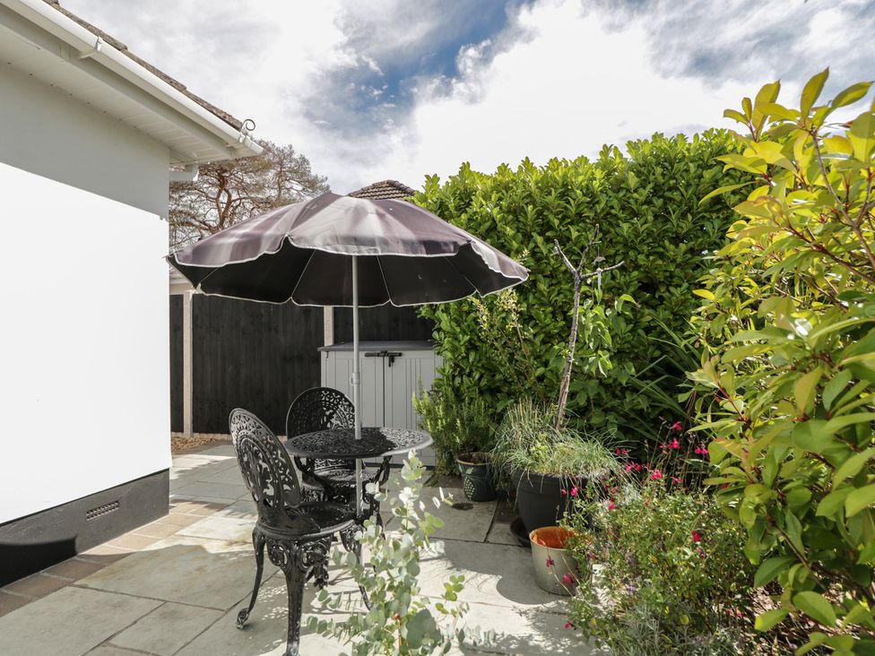 A garden area with a table and chairs under an umbrella at The Laurels in Wimborne Minster