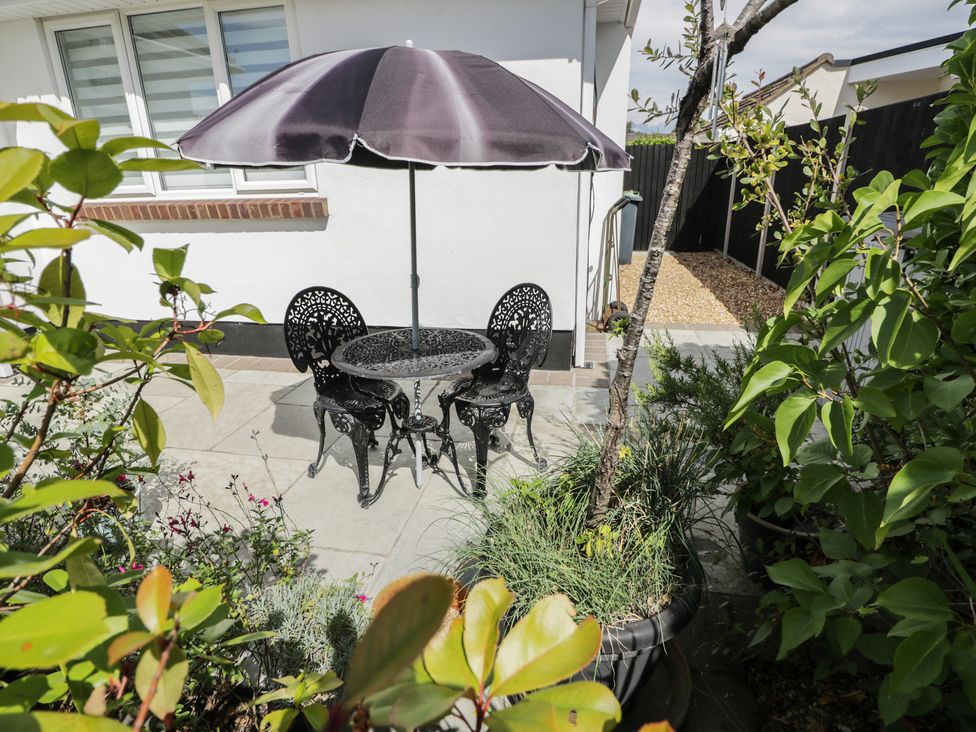 A garden with a table and chairs under an umbrella at The Laurels in Wimborne Minster