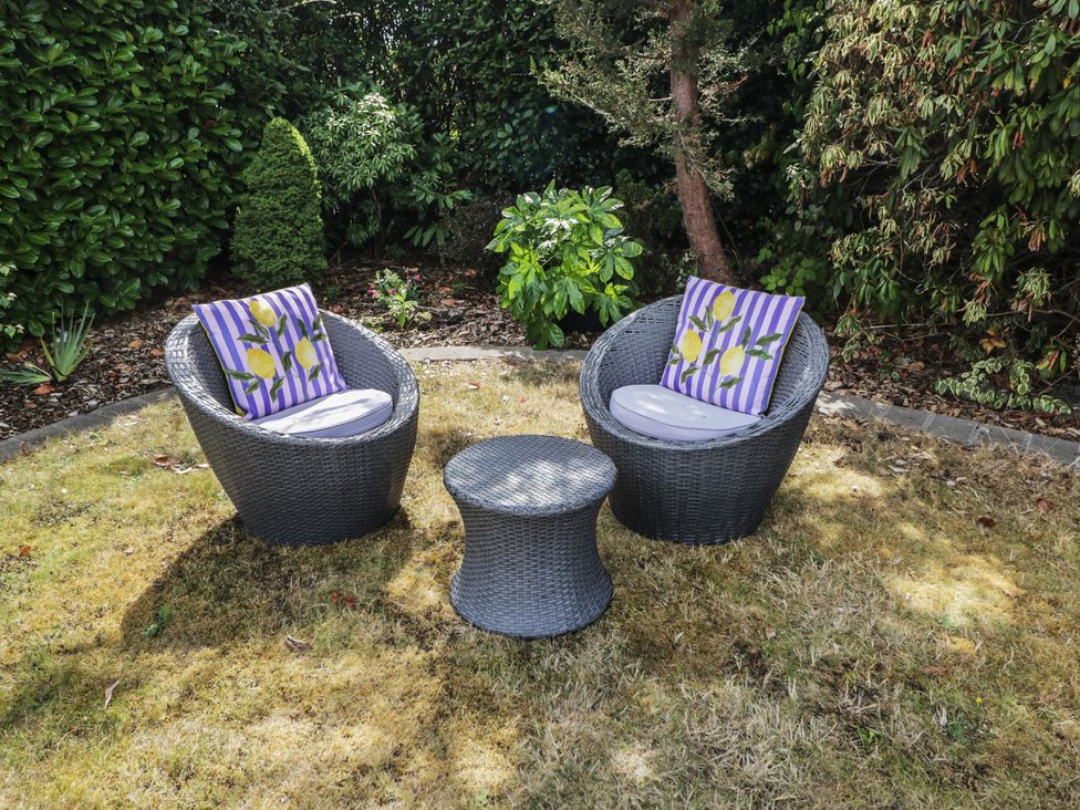 A garden with two outdoor chairs and a table at The Laurels in Wimborne Minster