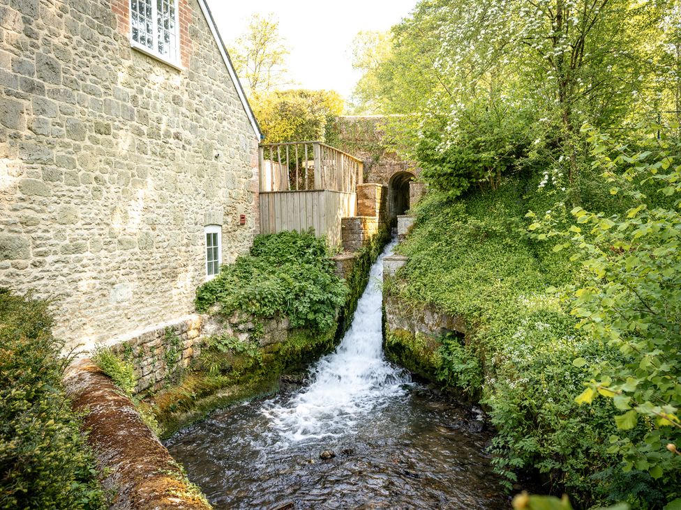 An outdoor area featuring a stone wall and a waterfall at French Mill in Shaftesbury