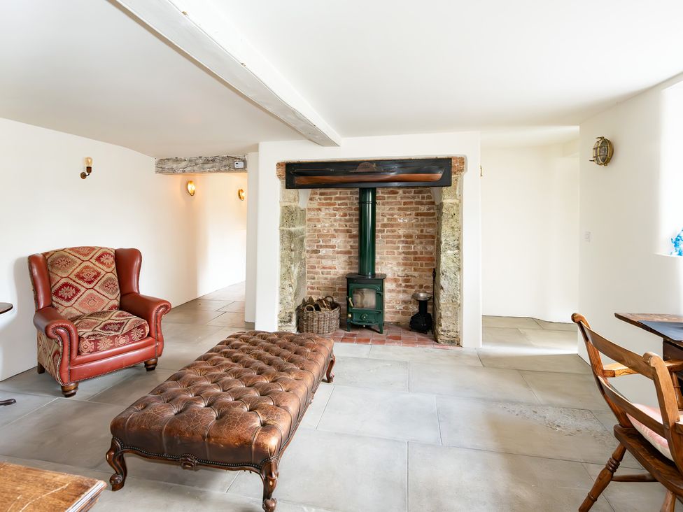 A living room with an armchair and a stove at French Mill in Shaftesbury