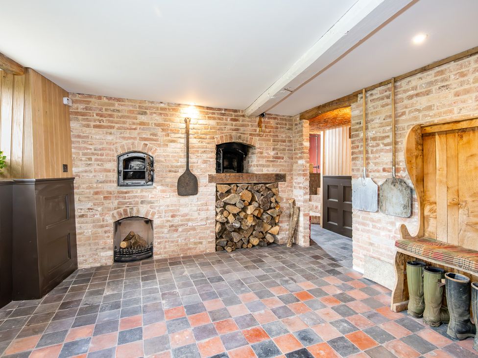 A kitchen with a brick wall and wood storage at French Mill in Shaftesbury