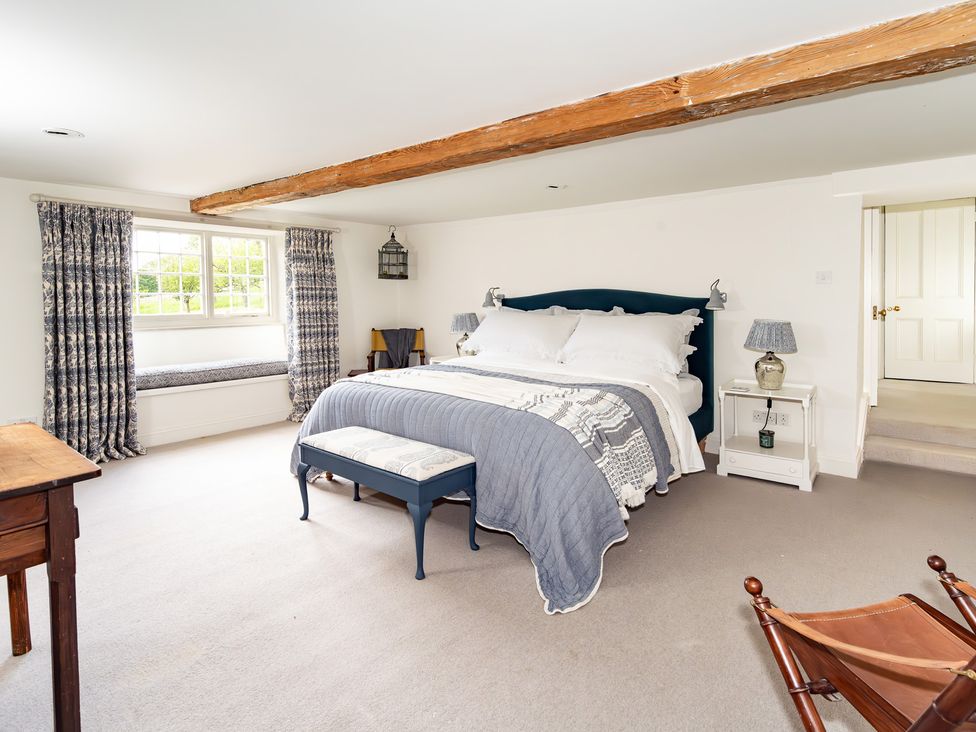 A bedroom with a bed and window seat at French Mill in Shaftesbury