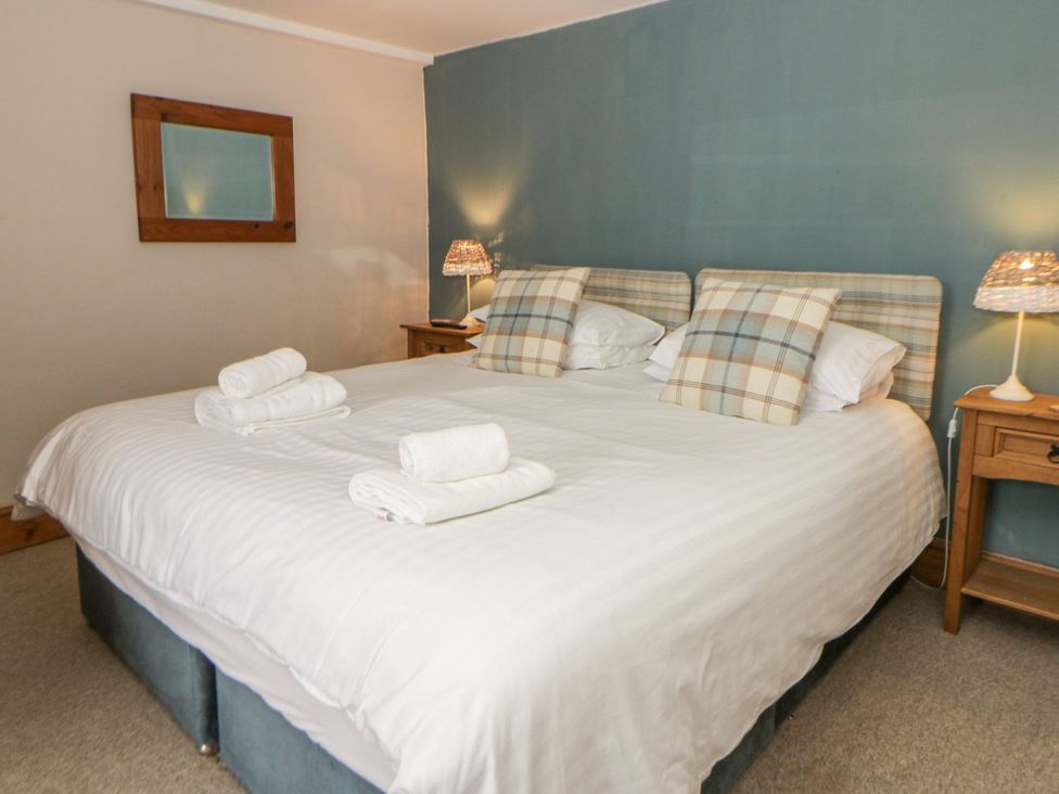 A bedroom with a double bed and lamps at Dewi Villa Apartment Aberaeron