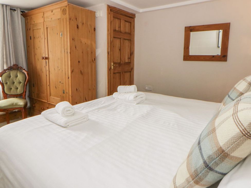 A bedroom with a bed and towels at Dewi Villa Apartment in Aberaeron