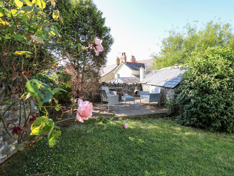 A garden with seating and flowers at Dewi Villa Apartment Aberaeron