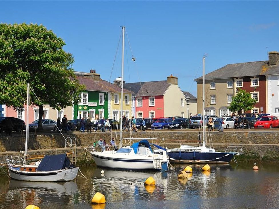 A waterfront view with boats and colorful buildings at Dewi Villa Apartment in Aberaeron