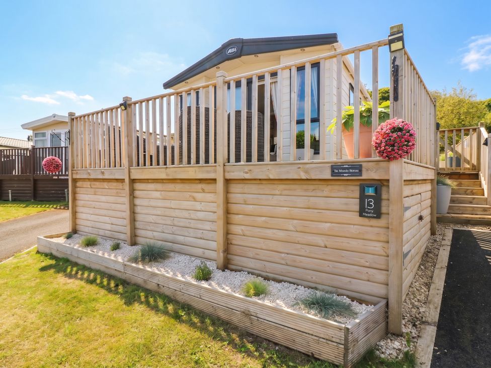An outdoor area with a wooden deck and planters at The Manor’s Retreat in Dunbar
