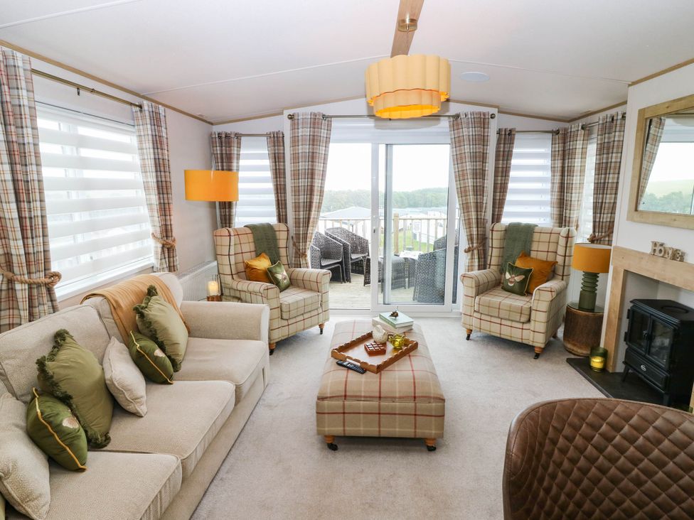 A living room with a sofa and chairs near a sliding door at The Manor’s Retreat in Dunbar