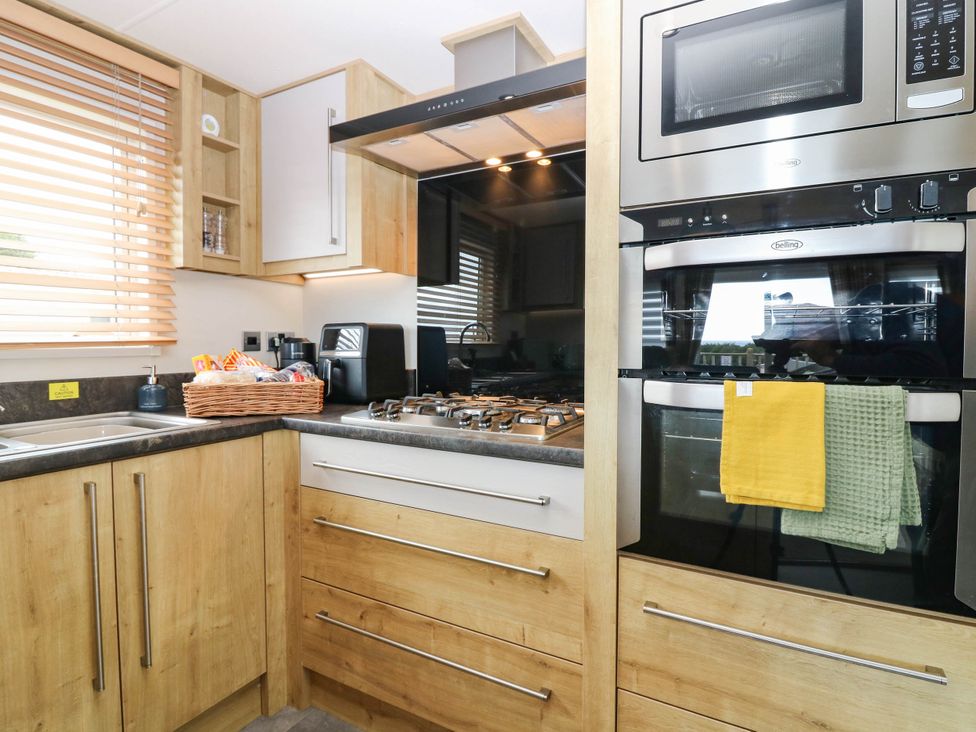 A kitchen with cabinets, sink, gas stove and oven at The Manor’s Retreat in Dunbar