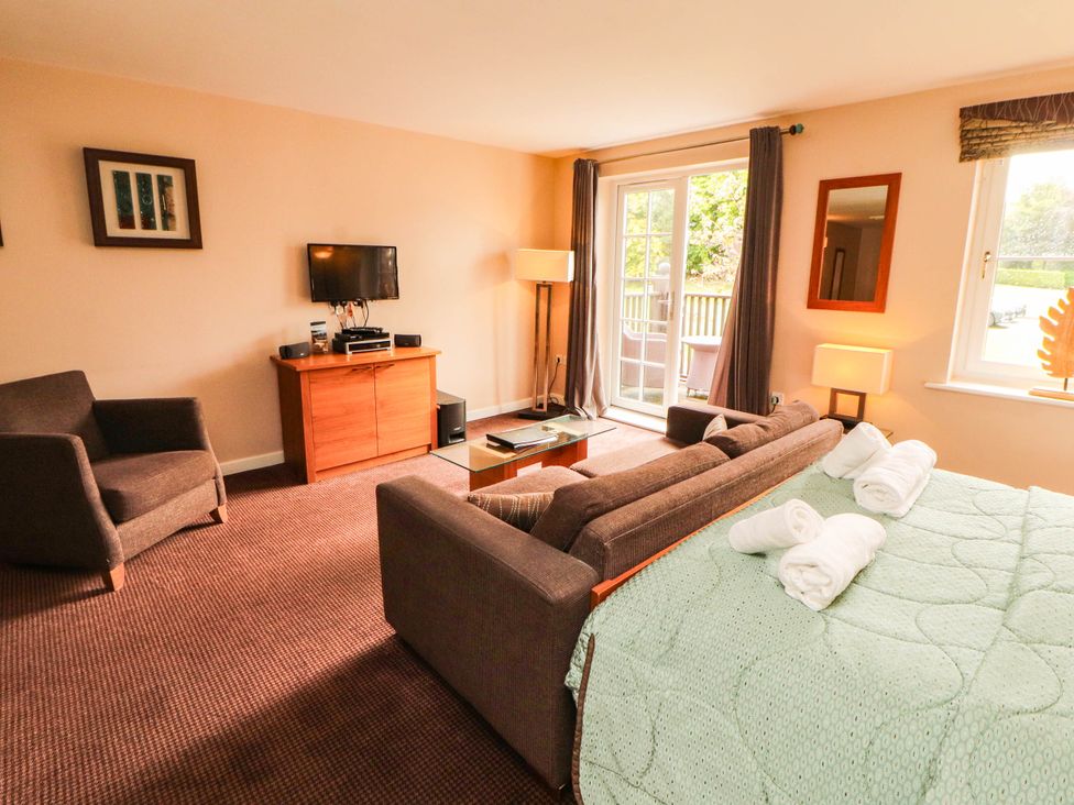 A living room with a bed, sofa, and television at Ullswater Apartment- No 15