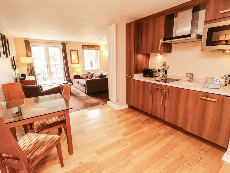 A living room with a dining area and kitchen features at Ullswater Apartment- No 15