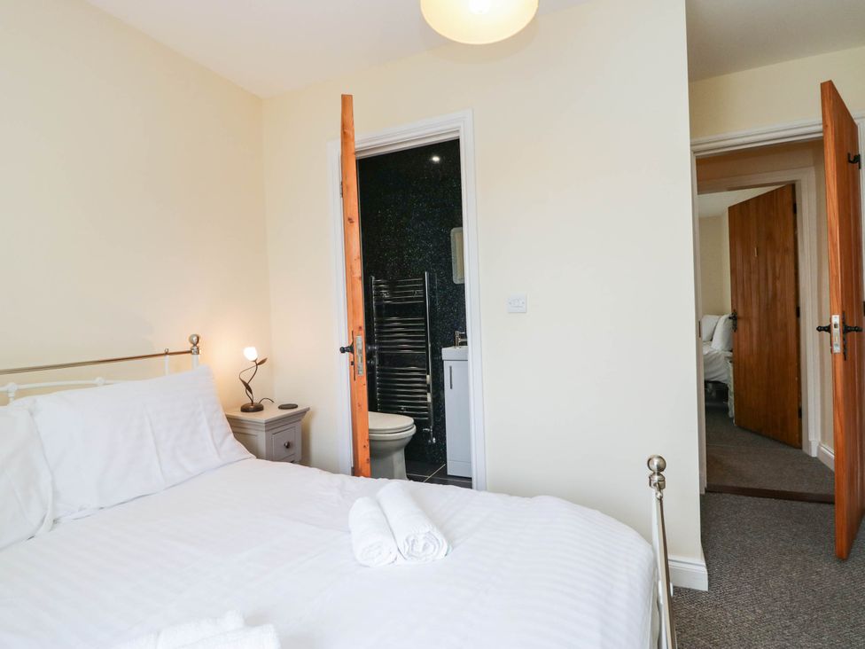 A bedroom with a bed and adjacent bathroom at Bramble near Cleator Moor