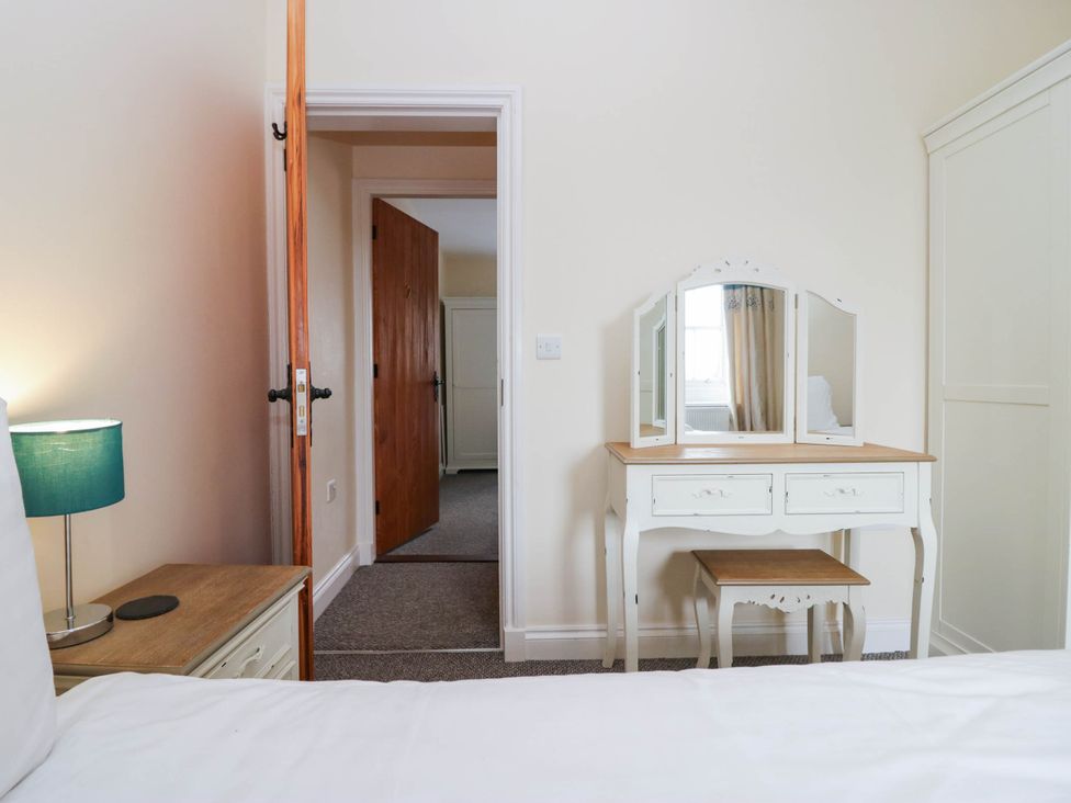 A bedroom with a bed and dressing table at Bramble near Cleator Moor