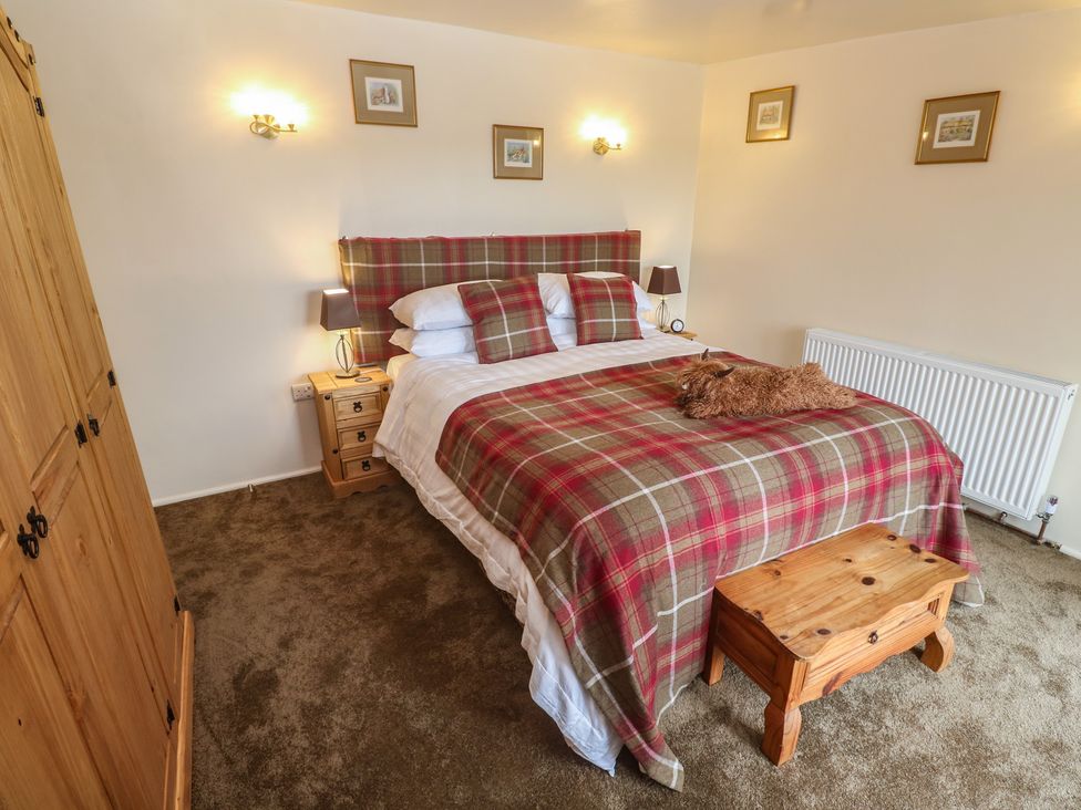 A bedroom with a bed and wardrobe at The Hideaway at Monterey in Helston