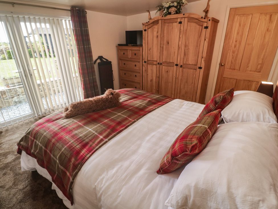 A bedroom with a bed and wardrobe at The Hideaway at Monterey Helston