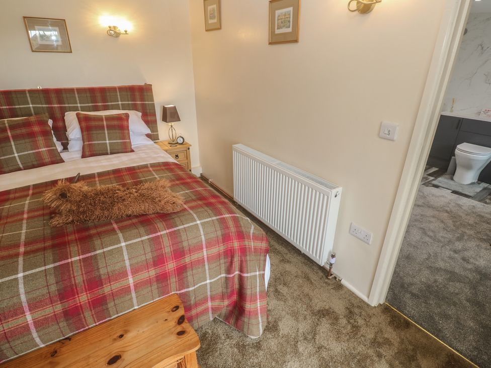 A bedroom with a bed and side table at The Hideaway at Monterey Helston