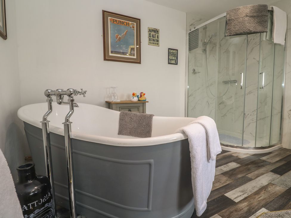 A bathroom with a bathtub and shower at The Hideaway at Monterey in Helston