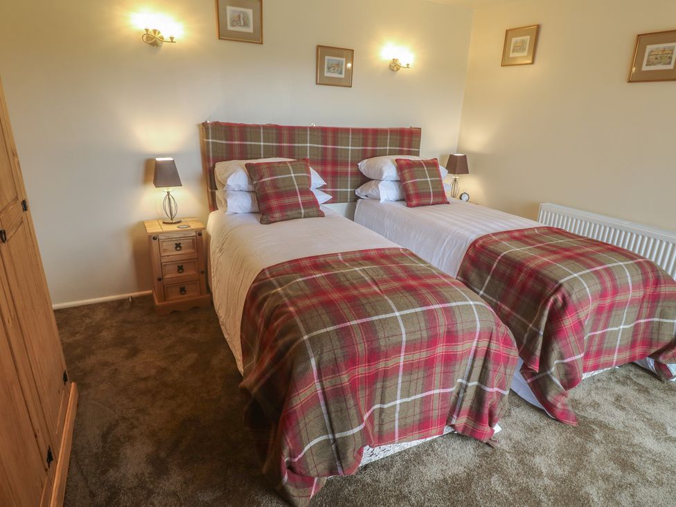 A bedroom with two single beds and bedside tables at The Hideaway at Monterey Helston