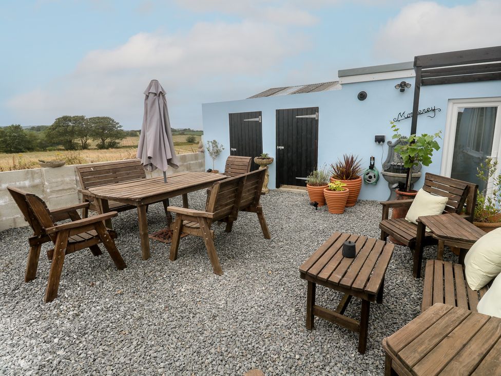 A garden with wooden furniture and planters at The Hideaway at Monterey Helston
