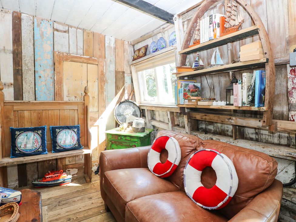 A snug with a sofa and bookshelf at Ladies of Bolton in Horsford