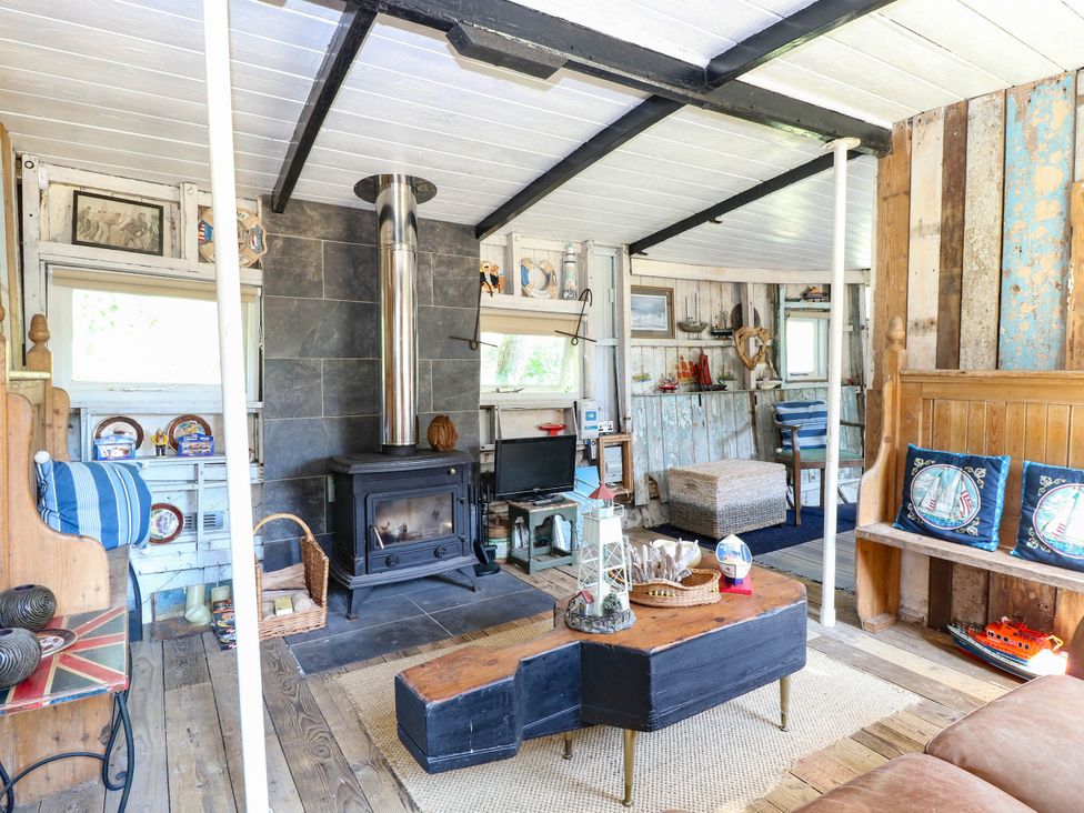 A living room with a stove and seating area at Ladies of Bolton in Horsford