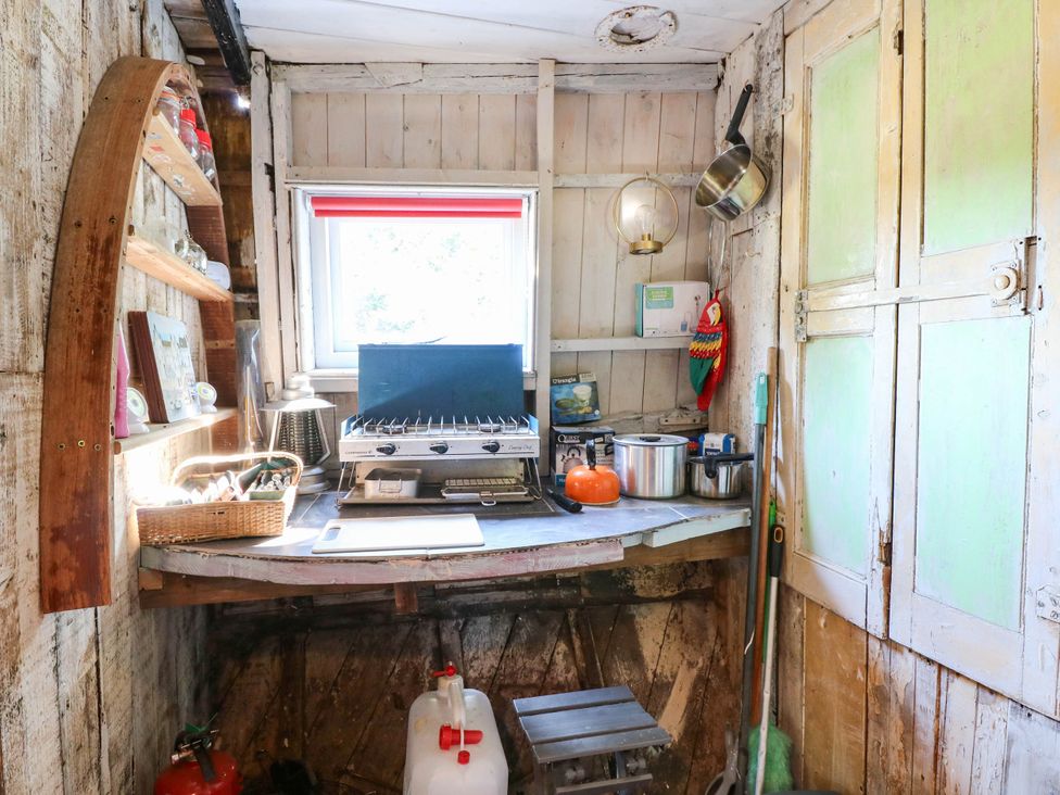 A kitchen with a stove and shelves at Ladies of Bolton in Horsford