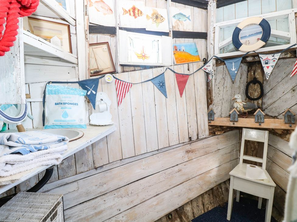 A bathroom with a mirror, towels, and a chair at Ladies of Bolton in Horsford