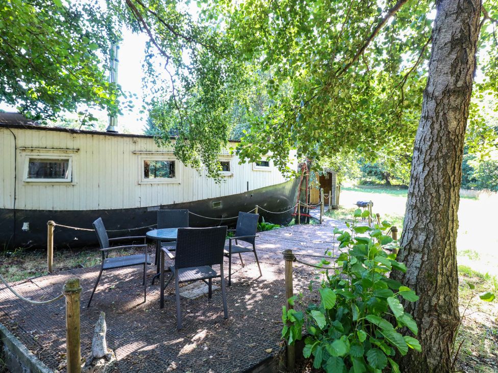 An outdoor seating area with a boat and table at Ladies of Bolton in Horsford