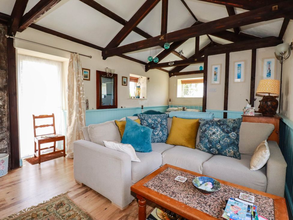A living room with a sofa and coffee table at The Jingle House in Tregony