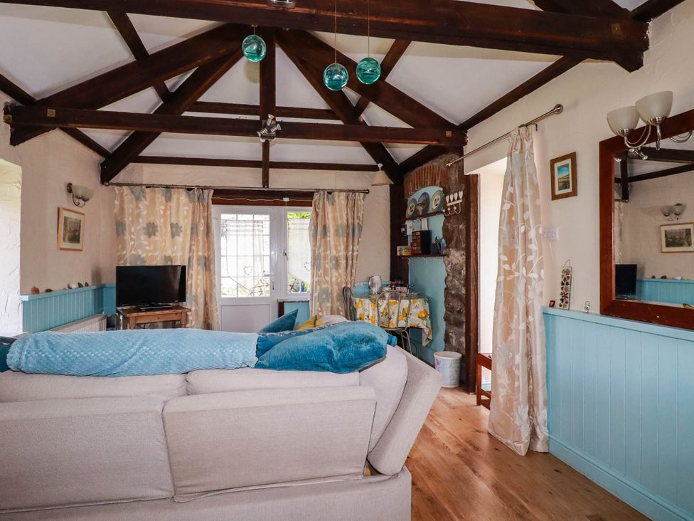 A living room with a sofa and television at The Jingle House in Tregony