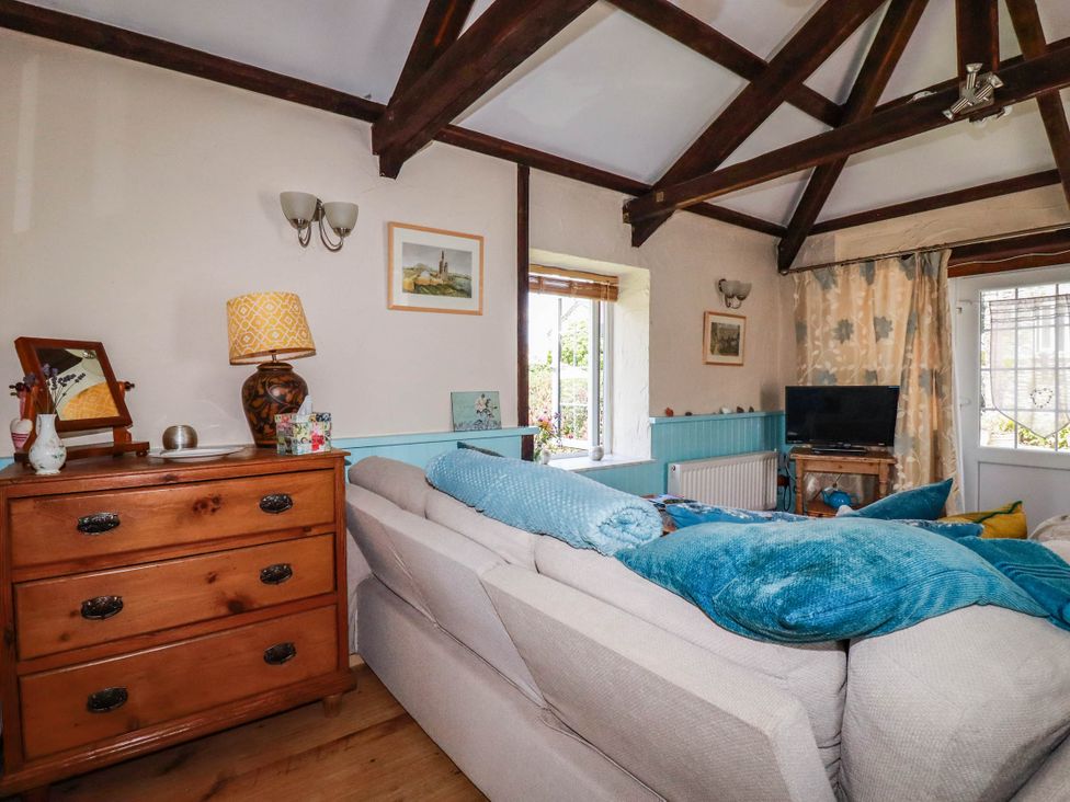 A living room with a couch and a tv at The Jingle House in Tregony